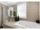 Luxurious bathroom with a soaking tub, a shower, and tiled walls at 627 New Road, Raleigh, NC 27608