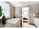 Elegant bathroom featuring a large tub, tile floors, and natural light at 627 New Road, Raleigh, NC 27608