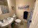 Bright bathroom featuring a sleek white sink, elegant wall art, and coordinated blue accents at 627 New Road, Raleigh, NC 27608