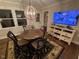 Dining room featuring wood flooring, a round table, a rustic light fixture, and a TV on the wall at 627 New Road, Raleigh, NC 27608