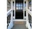 Elegant front door with black finish, sidelights, and a charming Welcome mat on gray porch at 627 New Road, Raleigh, NC 27608