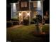 Charming home exterior featuring manicured landscaping, illuminated by outdoor lighting at night at 627 New Road, Raleigh, NC 27608