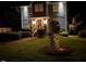 Charming home exterior featuring manicured landscaping, illuminated by outdoor lighting at night at 627 New Road, Raleigh, NC 27608