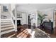 Bright hallway featuring hardwood floors, a fireplace, and staircase at 627 New Road, Raleigh, NC 27608