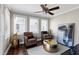 Bright living room featuring two chairs, three windows, hardwood floors, and neutral-colored walls at 627 New Road, Raleigh, NC 27608