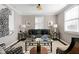 Comfortable living room featuring a plush sofa, patterned pillows, and window blinds at 627 New Road, Raleigh, NC 27608
