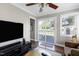 The living room features an entertainment center, a ceiling fan, and sliding glass doors to a wooden deck at 627 New Road, Raleigh, NC 27608