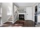 Bright living room features a fireplace, staircase, wood floors, and neutral paint at 627 New Road, Raleigh, NC 27608