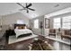 A well-lit bedroom with a vaulted ceiling, a fan, hardwood floors, and two chairs at 627 New Road, Raleigh, NC 27608
