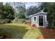 Well-maintained backyard shed surrounded by lush landscaping and mulch, offering ample storage space at 627 New Road, Raleigh, NC 27608
