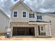 New two-story home with a two-car garage, stone accents, and light-colored siding at 713 Emerald Bay Cir # 834, Raleigh, NC 27529