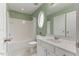 Bathroom featuring a tub and shower combination, bright vanity, neutral tile, and a decorative oval window at 7856 Spungold St, Raleigh, NC 27617