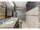 Modern bathroom with a beautiful stone archway, dark granite countertops, and glass enclosed shower at 7856 Spungold St, Raleigh, NC 27617