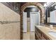 Modern bathroom with a beautiful stone archway, dark granite countertops, and tile flooring at 7856 Spungold St, Raleigh, NC 27617