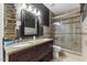 Modern bathroom with granite countertops, dual vanity, a dark accent wall, and glass enclosed shower at 7856 Spungold St, Raleigh, NC 27617