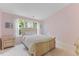 Cozy bedroom with a queen-size bed and bright windows providing ample natural light and calming pink walls at 7856 Spungold St, Raleigh, NC 27617