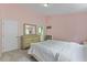 Bedroom with light pink walls, carpet, and a large dresser/mirror and a view to an ensuite bath at 7856 Spungold St, Raleigh, NC 27617