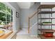 Light-filled foyer with stairway features neutral paint, bright windows and an industrial wood and metal shelving unit at 7856 Spungold St, Raleigh, NC 27617