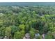 An aerial view of the property and surrounding area highlighting dense trees at 7916 Foxwood Dr, Raleigh, NC 27615