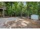 The backyard features a shed, a rock lined area, and ample space surrounded by mature trees at 7916 Foxwood Dr, Raleigh, NC 27615