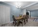 Dining room with a wooden table, chairs, and chandelier, accented by blue walls and neutral flooring at 7916 Foxwood Dr, Raleigh, NC 27615