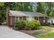 Quaint brick home featuring a charming entryway and mature landscaping, set back from the road at 7916 Foxwood Dr, Raleigh, NC 27615