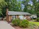 Traditional brick home with a well-manicured lawn and established landscaping, showcasing suburban charm at 7916 Foxwood Dr, Raleigh, NC 27615