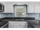 Close up of a well-lit kitchen featuring granite countertops, stainless appliances, and white cabinets at 7916 Foxwood Dr, Raleigh, NC 27615