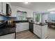 Well-lit kitchen featuring granite countertops, stainless appliances, white cabinets, and modern fixtures at 7916 Foxwood Dr, Raleigh, NC 27615