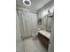 Well-lit bathroom with a modern vanity, shower, and white tile floor at 80 Stoneridge Rd, Durham, NC 27705