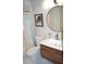 Bathroom featuring a shower-over-tub combo, round mirror, and modern vanity at 80 Stoneridge Rd, Durham, NC 27705
