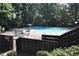 Community pool with lounge chairs, an umbrella, and mature trees surrounding it at 80 Stoneridge Rd, Durham, NC 27705