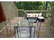 Inviting deck with outdoor seating, glass table, and wooded views offers a relaxing space at 80 Stoneridge Rd, Durham, NC 27705