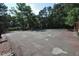 Community tennis court surrounded by trees provides a recreational amenity for residents at 80 Stoneridge Rd, Durham, NC 27705