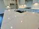 Close-up of a kitchen with quartz countertops, stainless steel sink and appliances, and lots of storage at 820 Emerald Bay Cir # 762, Raleigh, NC 27610