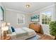 Staged bedroom featuring hardwood floors, two windows, and a wooden dresser at 919 Chester St, Durham, NC 27701