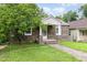 Quaint stone home featuring a welcoming porch and lush green lawn with a mature tree at 919 Chester St, Durham, NC 27701