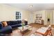 A cozy living room with a blue sectional, stylish coffee table, and light-filled window at 919 Chester St, Durham, NC 27701