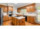 View of an updated kitchen with an island cooktop, stainless steel appliances, and window views at 101 Turnberry Ln, Cary, NC 27511