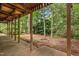 Covered patio beneath a wooden deck, providing a shaded outdoor space to enjoy the lush surroundings at 101 Turnberry Ln, Cary, NC 27511