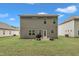 Backyard featuring a gray home exterior, grill on patio, and grassy lawn under a bright blue sky at 111 S Rose Hill Dr, Clayton, NC 27520