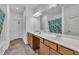 Bright bathroom featuring a double sink vanity, a large mirror, and a shower with a vibrant, tropical-themed curtain at 111 S Rose Hill Dr, Clayton, NC 27520