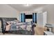 Spacious bedroom with a plush, floral-patterned bed, a wall-mounted TV, and neutral carpet at 111 S Rose Hill Dr, Clayton, NC 27520