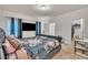 Cozy bedroom with a plush, floral-patterned bed, a wall-mounted TV, and neutral carpet at 111 S Rose Hill Dr, Clayton, NC 27520