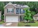 Charming two-story home with grey siding, blue shutters, well-manicured lawn and solar panels at 111 S Rose Hill Dr, Clayton, NC 27520