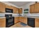 Well-equipped kitchen featuring warm wood cabinets, modern appliances, and a bright window over sink at 111 S Rose Hill Dr, Clayton, NC 27520