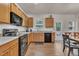 Spacious kitchen with wood cabinets, black appliances, and seamless access to the dining area at 111 S Rose Hill Dr, Clayton, NC 27520