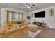 Comfortable living room featuring a large yellow sectional sofa, TV, and hardwood floors at 111 S Rose Hill Dr, Clayton, NC 27520
