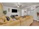 Comfortable living room featuring plush corduroy sofa, ceiling fan, and wall-mounted television at 111 S Rose Hill Dr, Clayton, NC 27520