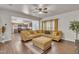 Spacious living room flows into kitchen with a large yellow sectional sofa and wood flooring at 111 S Rose Hill Dr, Clayton, NC 27520